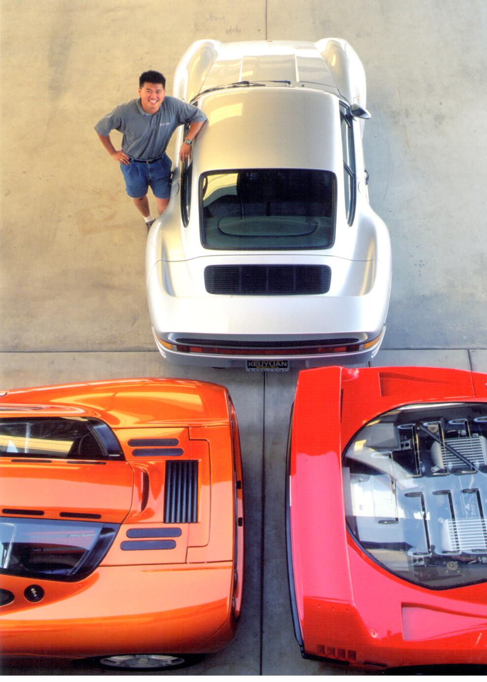 Patrick Hong standing with a Porsche 959, McLaren F1, and Ferrari F40