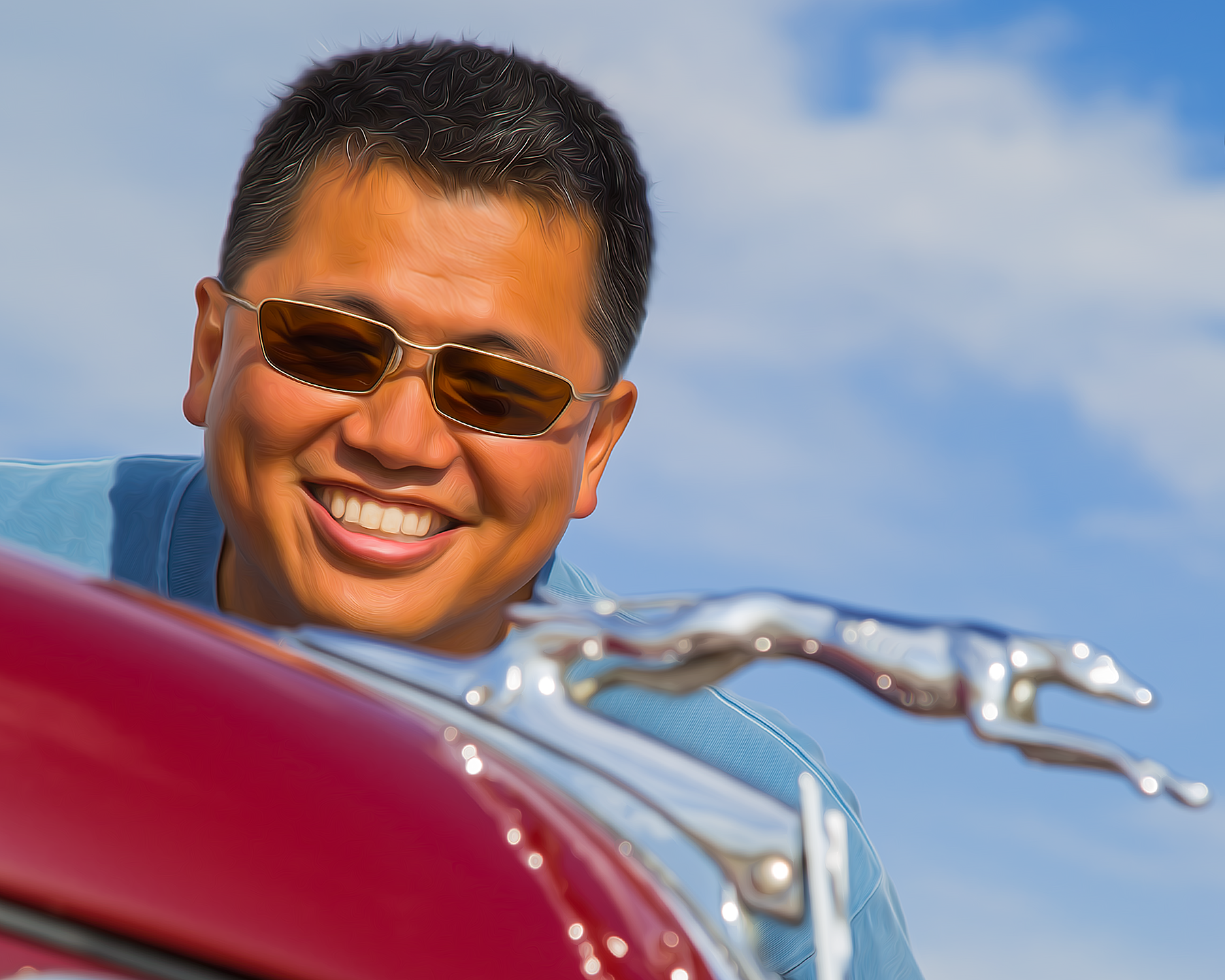 Patrick Hong leaning over the hood of a classic red car